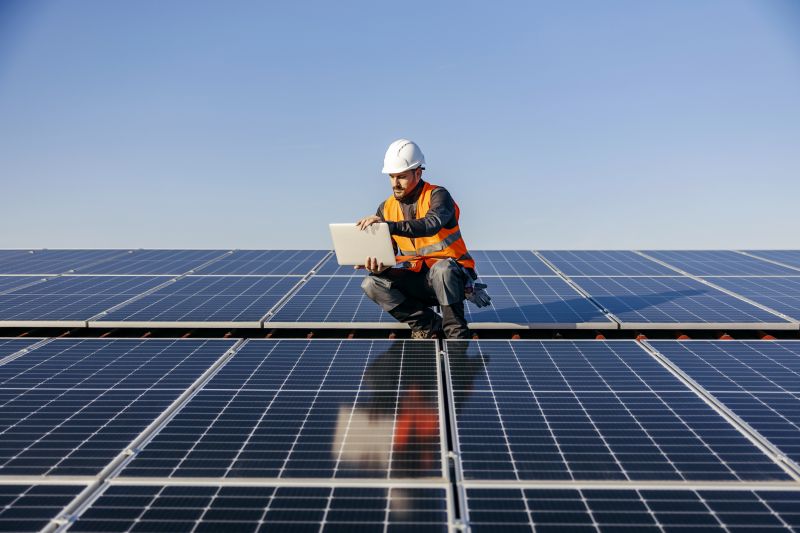 Professional solar panel technicians working on a roof